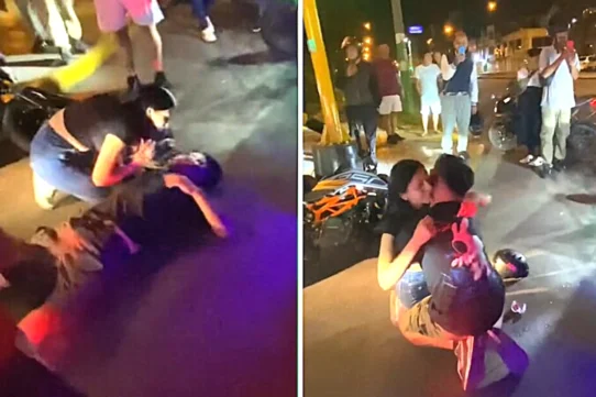 A prankster lay motionless beside his toppled bike while his girlfriend rushed over in tears