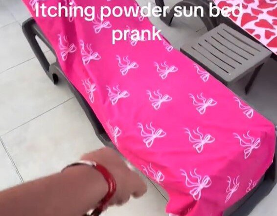 A hotel worker in Rhodes clears towels off reserved sunbeds