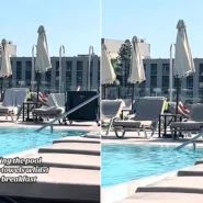 A hotel worker in Rhodes clears towels off reserved sunbeds