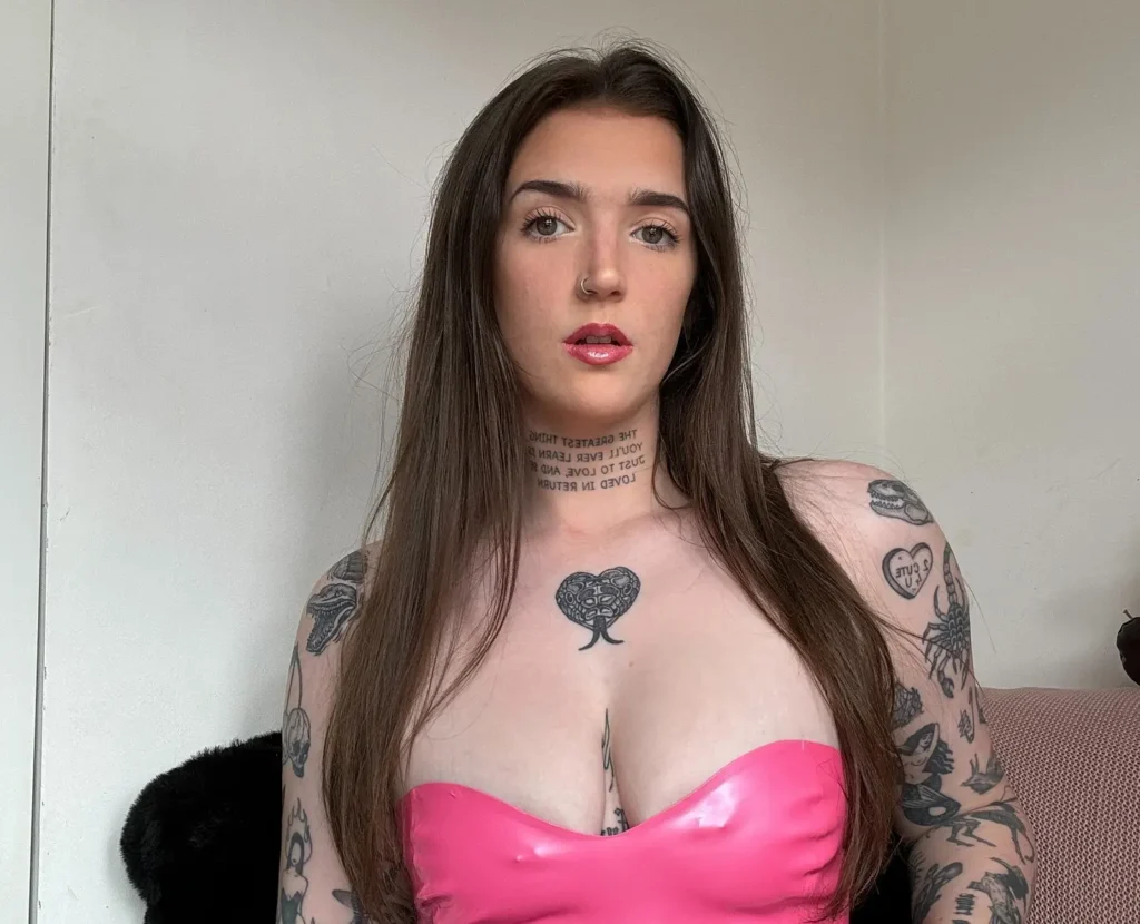 Woman with sleeve tattoos in pink latex top and black skirt.