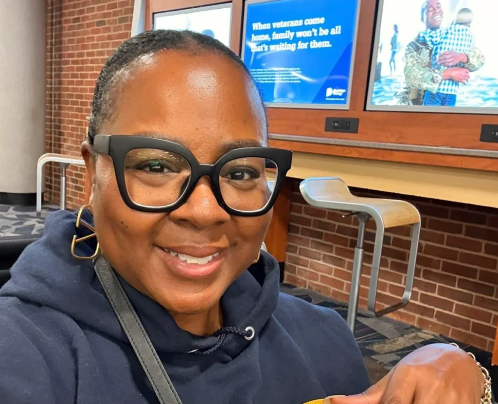 Tomiko Harvey smiling at the camera at a charging station.